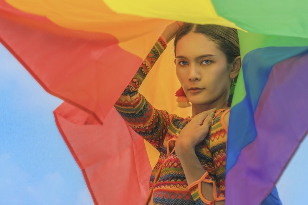 transgender female holding a rainbow flag after having penile inversion surgery